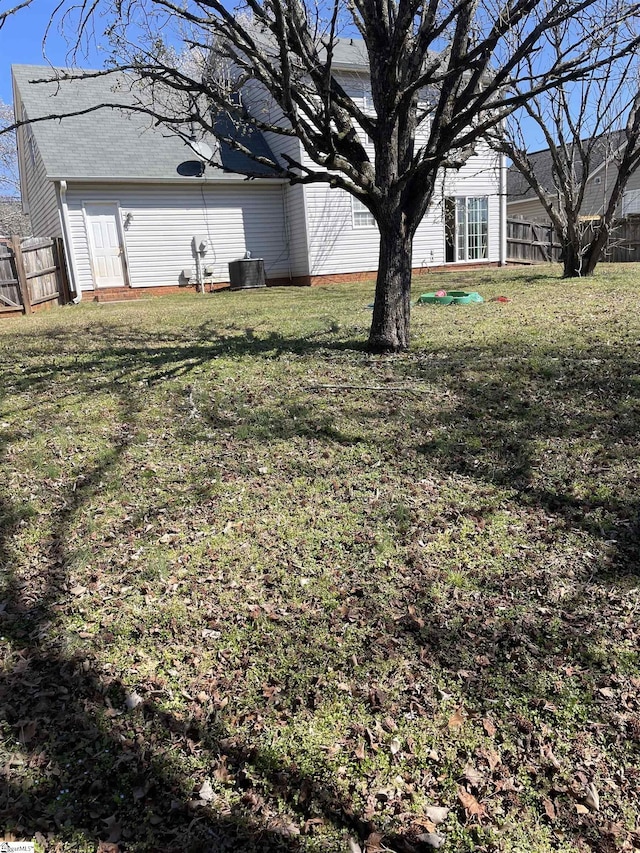 view of yard featuring fence and central air condition unit