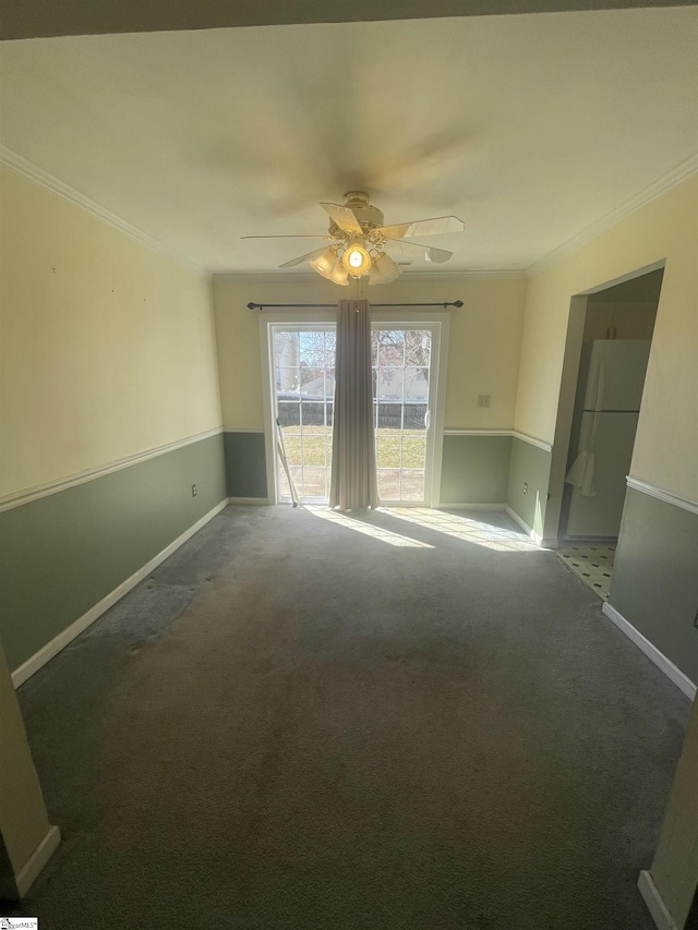 spare room featuring ornamental molding, carpet, a ceiling fan, and baseboards