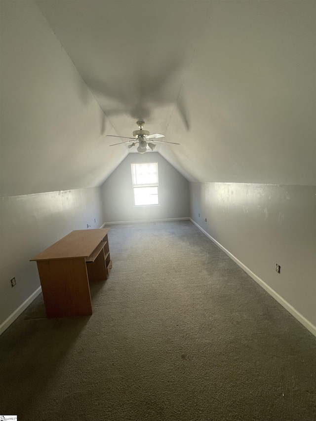 bonus room with lofted ceiling, dark colored carpet, and baseboards