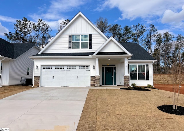 view of front facade featuring a shingled roof, concrete driveway, an attached garage, central AC, and board and batten siding