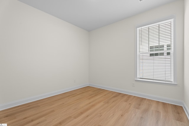 unfurnished room with baseboards and light wood-style floors