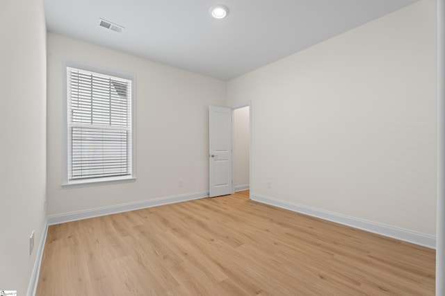 unfurnished room with light wood-type flooring, baseboards, visible vents, and recessed lighting