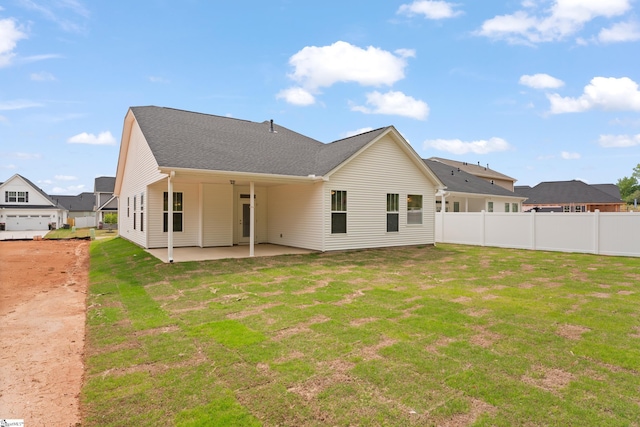 back of property with a lawn, a patio, and fence