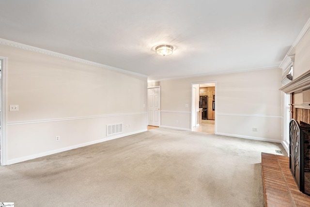 unfurnished living room featuring a brick fireplace, visible vents, crown molding, and light colored carpet