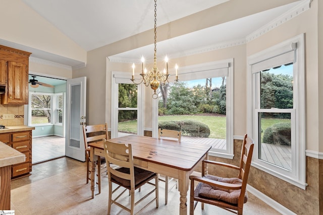 dining area with lofted ceiling, baseboards, crown molding, and ceiling fan with notable chandelier