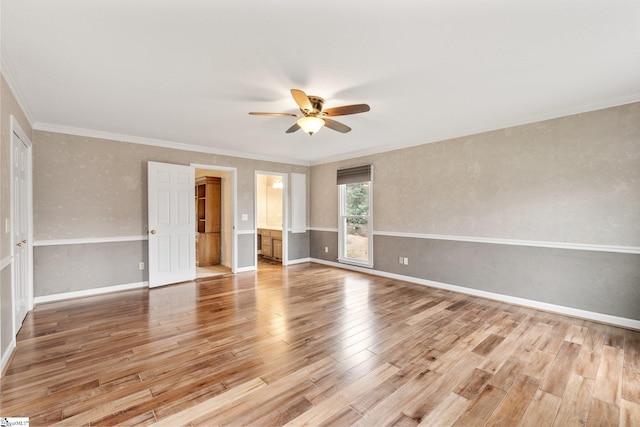 spare room featuring light wood finished floors, baseboards, ornamental molding, and ceiling fan