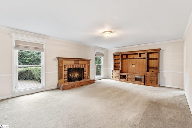 unfurnished living room with carpet, a fireplace, ornamental molding, and baseboards