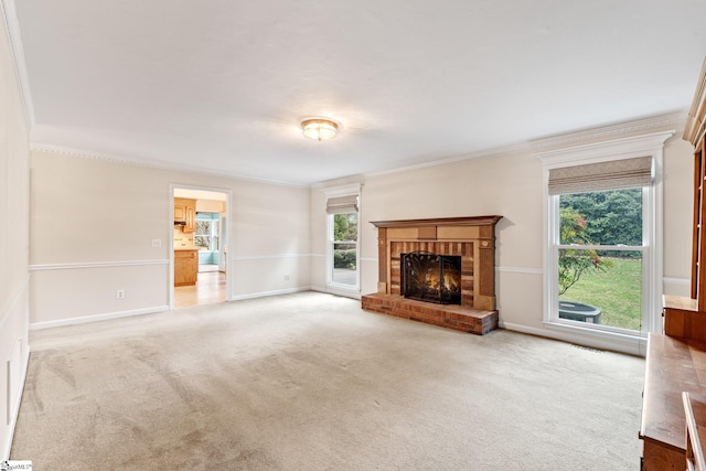 unfurnished living room with ornamental molding, light carpet, a fireplace, and baseboards