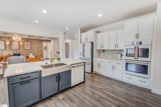 kitchen with white appliances, white cabinets, and a sink