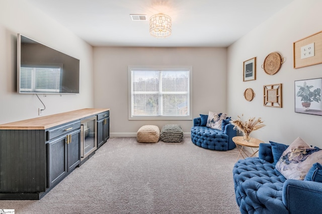 sitting room featuring carpet flooring, visible vents, and baseboards