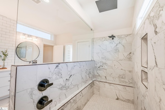 bathroom featuring tiled shower and visible vents