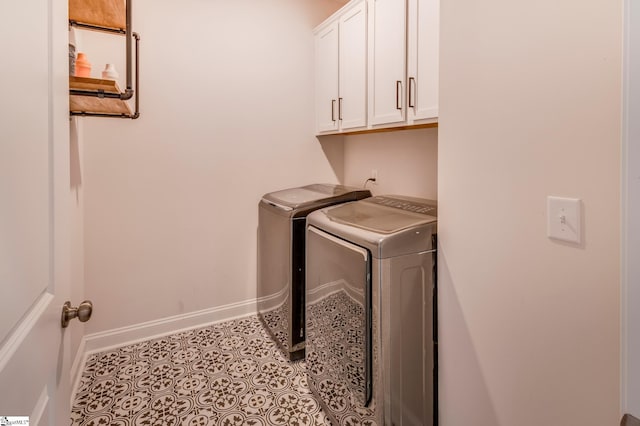 washroom featuring light tile patterned floors, cabinet space, baseboards, and separate washer and dryer