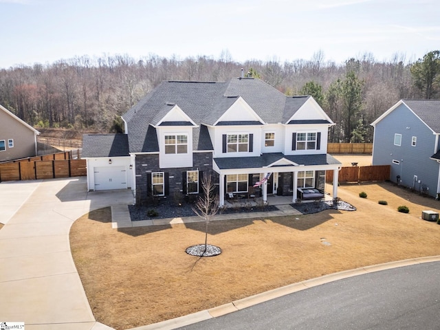 view of front of house with driveway, a shingled roof, fence, and a front lawn