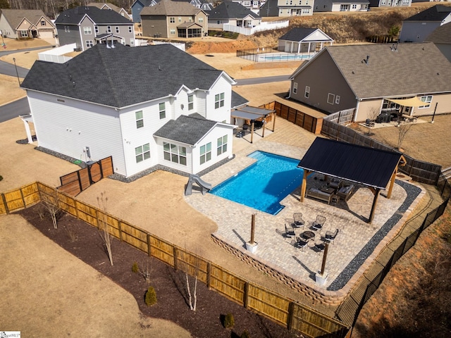 view of swimming pool featuring a fenced backyard, a residential view, and a patio