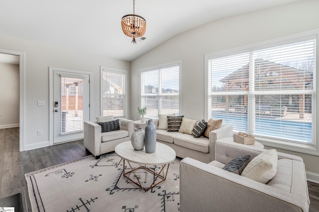 living area with vaulted ceiling, baseboards, and wood finished floors