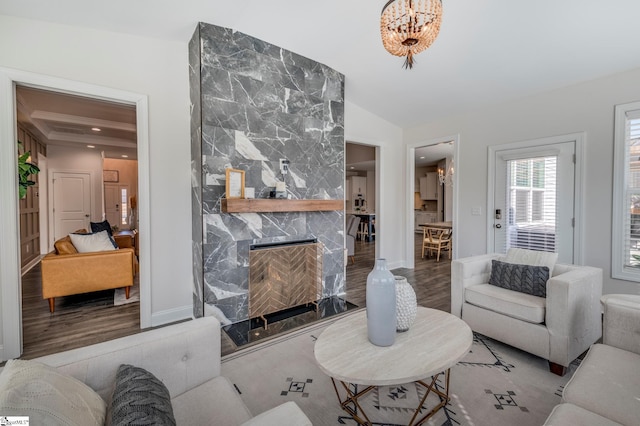 living area featuring baseboards, a premium fireplace, wood finished floors, vaulted ceiling, and recessed lighting