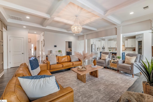 living room with dark wood-style floors, beam ceiling, visible vents, a chandelier, and ornate columns