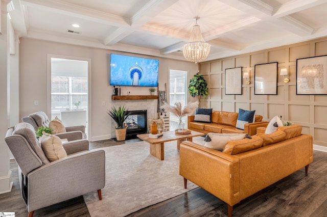 living room featuring visible vents, a decorative wall, beamed ceiling, and wood finished floors