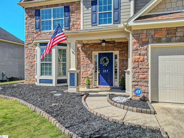 view of exterior entry featuring stone siding and an attached garage