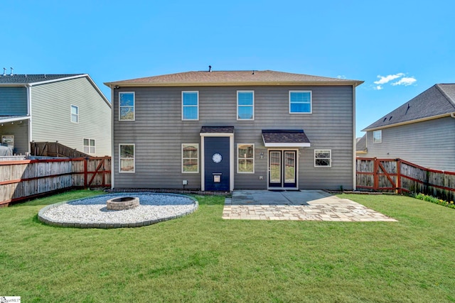 back of property featuring a yard, an outdoor fire pit, a fenced backyard, and a patio