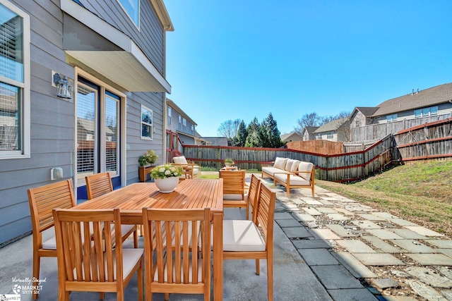 view of patio with outdoor dining area, a fenced backyard, a residential view, and an outdoor hangout area