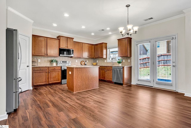 kitchen featuring stainless steel appliances, brown cabinetry, visible vents, and dark wood-style flooring