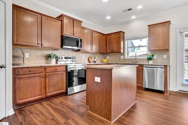 kitchen featuring appliances with stainless steel finishes, dark wood-style flooring, visible vents, and ornamental molding