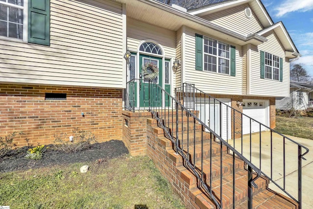 property entrance with a garage and brick siding