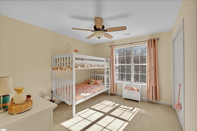 carpeted bedroom featuring baseboards, visible vents, and a ceiling fan