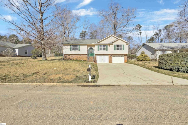 split foyer home featuring driveway, brick siding, a front lawn, and an attached garage