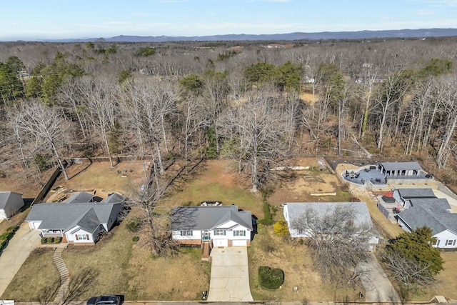 drone / aerial view with a wooded view and a mountain view