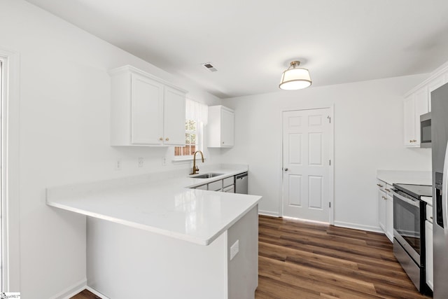 kitchen featuring dark wood-style flooring, stainless steel appliances, light countertops, visible vents, and a sink