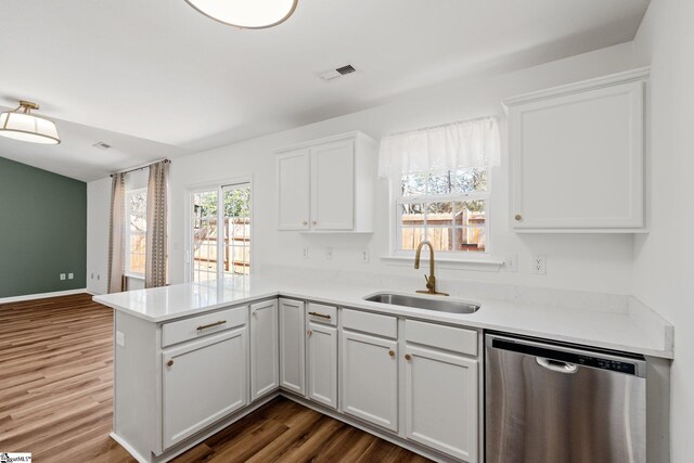 kitchen with a peninsula, a sink, visible vents, dark wood-style floors, and dishwasher