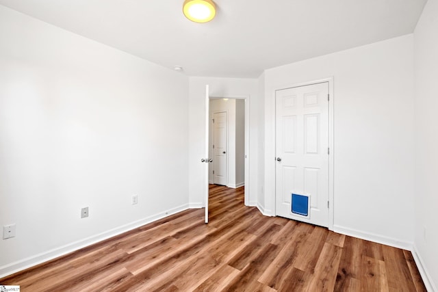 empty room featuring light wood-style flooring and baseboards