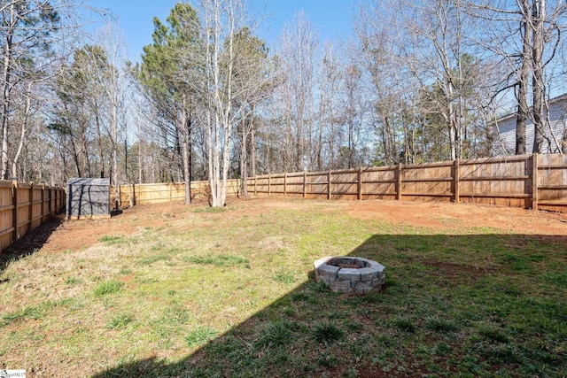 view of yard with a fenced backyard and a fire pit