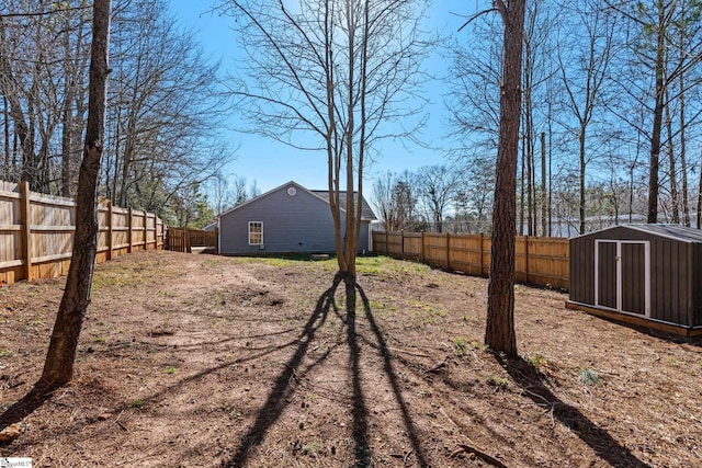 view of yard with a fenced backyard, a storage unit, and an outdoor structure