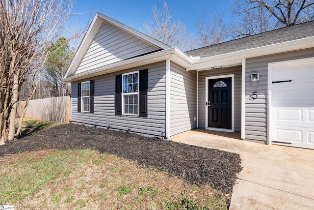 exterior space featuring fence and an attached garage