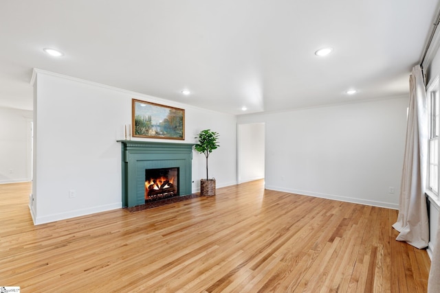 unfurnished living room with light wood-type flooring, a fireplace, baseboards, and recessed lighting