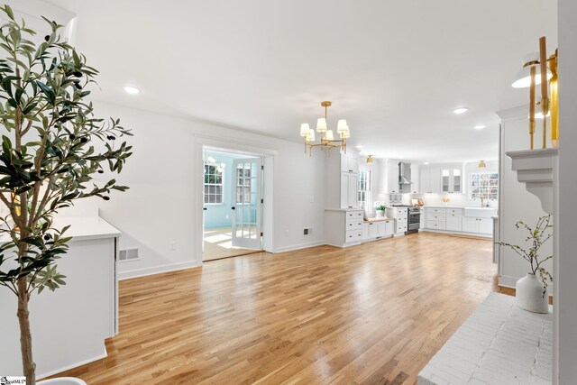 unfurnished living room featuring light wood-type flooring, visible vents, baseboards, and recessed lighting