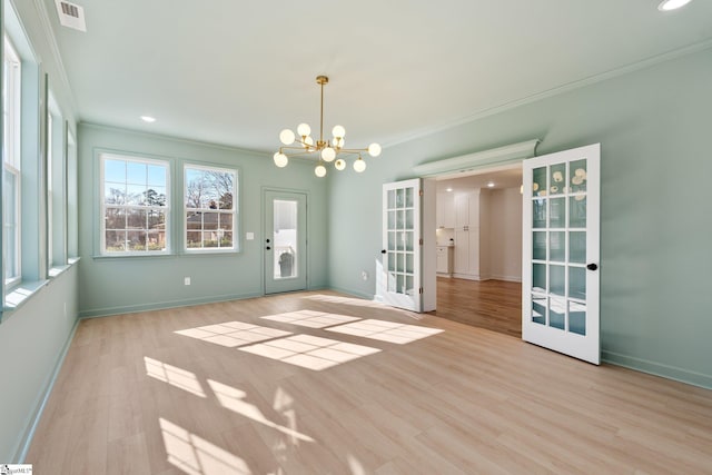 spare room with visible vents, ornamental molding, wood finished floors, and french doors