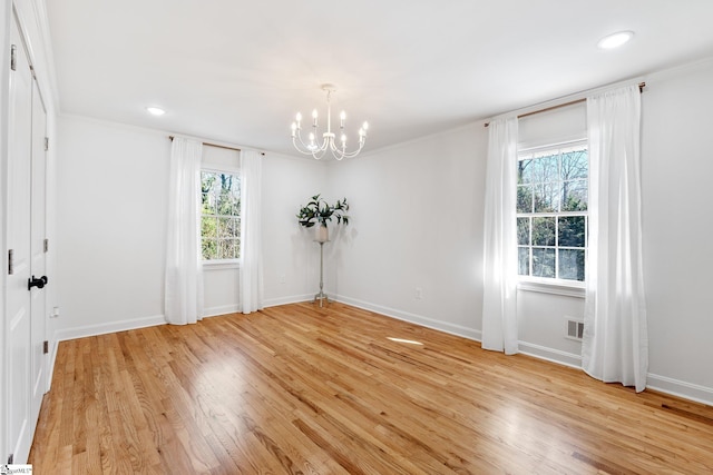 empty room featuring light wood-type flooring, an inviting chandelier, baseboards, and visible vents