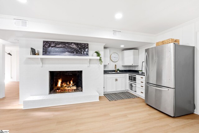 kitchen featuring stainless steel appliances, a sink, white cabinetry, open shelves, and dark countertops