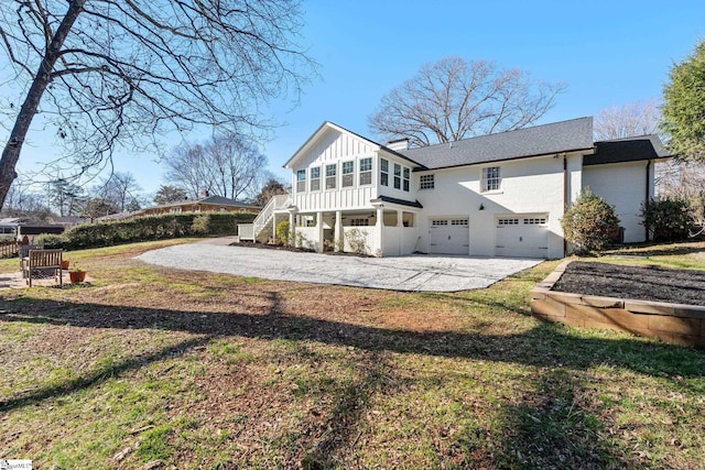 back of house featuring gravel driveway, an attached garage, stairs, and board and batten siding