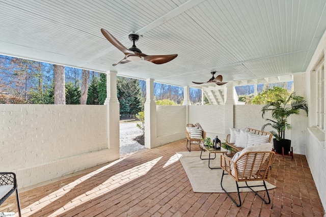 sunroom / solarium with a ceiling fan and a healthy amount of sunlight