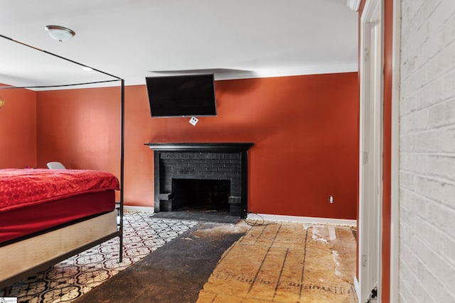 bedroom with concrete block wall, a fireplace, and baseboards