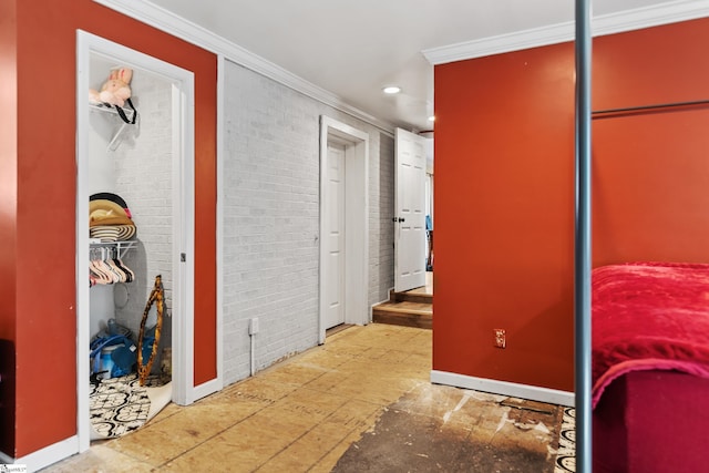 hall with brick wall, ornamental molding, baseboards, and recessed lighting