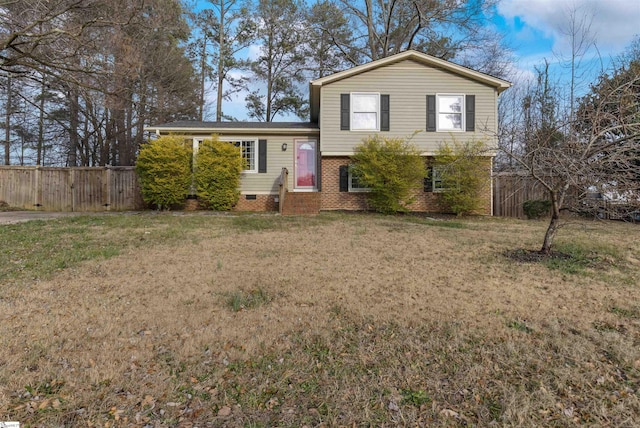 tri-level home with brick siding, crawl space, a front yard, and fence