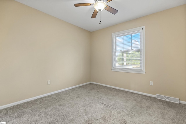 unfurnished room with carpet, visible vents, ceiling fan, and baseboards