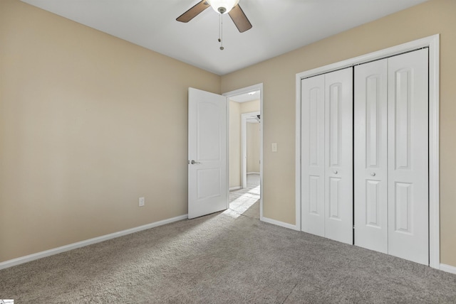 unfurnished bedroom with carpet floors, a closet, a ceiling fan, and baseboards