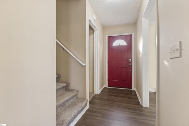 entryway with baseboards, dark wood finished floors, stairway, and a textured ceiling